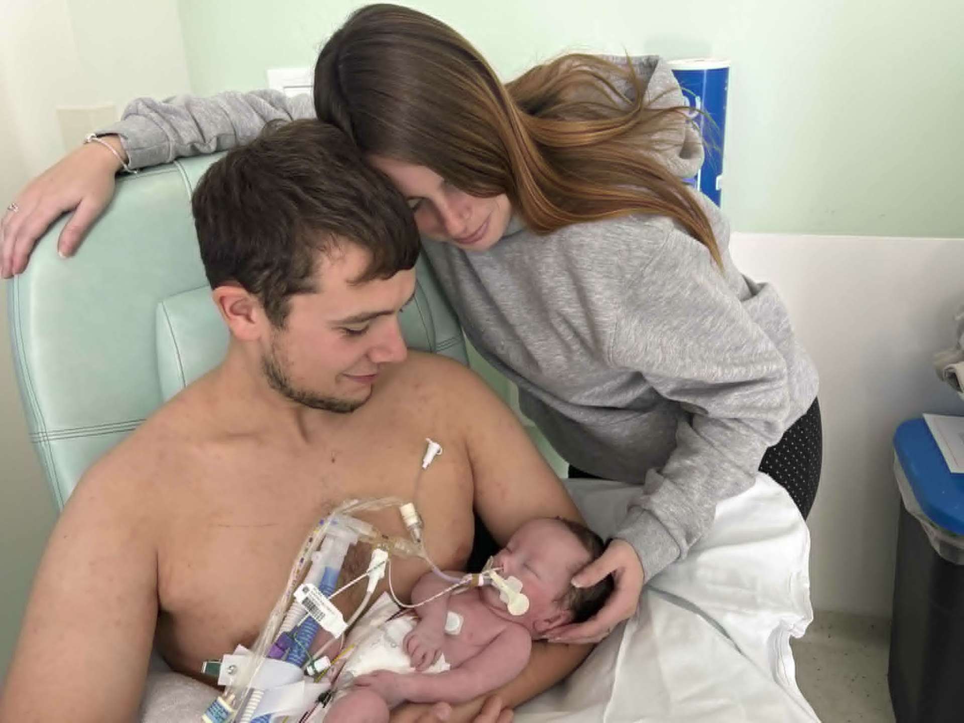 Dad holding Noah skin-to-skin while Mum leans in